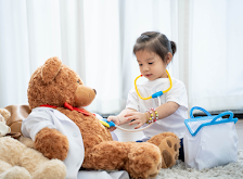 girl playing with teddy